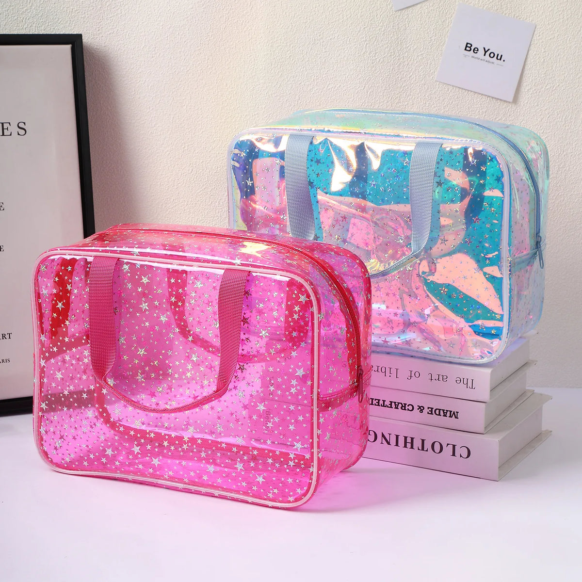 A pink clear waterproof makeup organizer bag next to a light blue and pink cosmetic case.