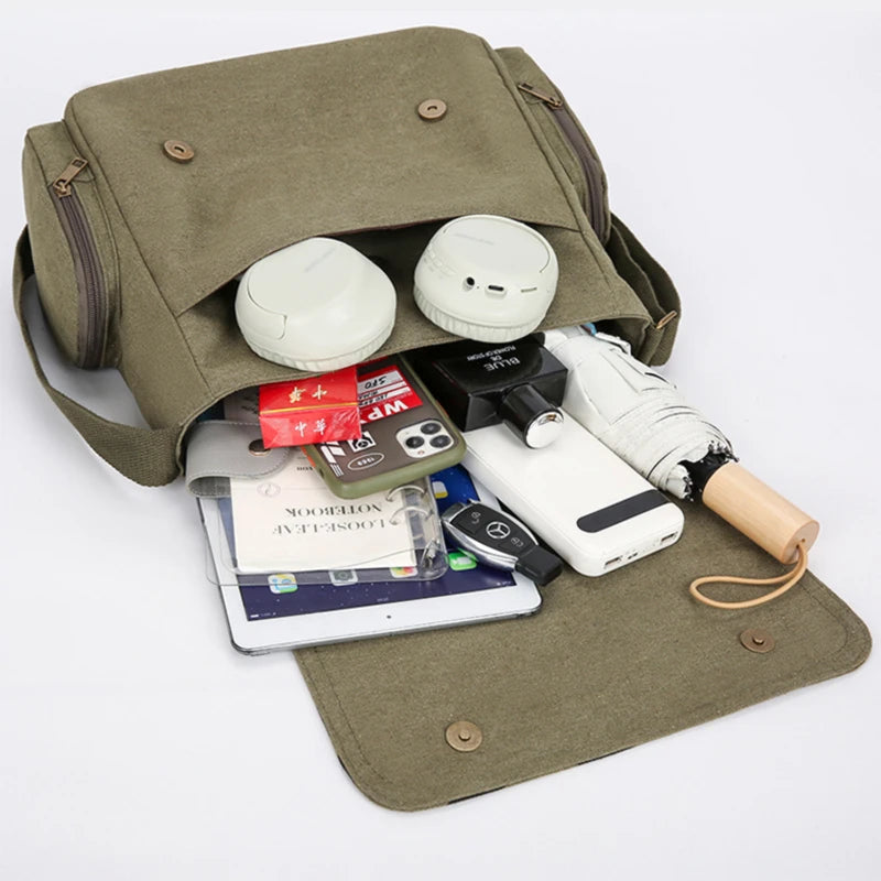 Un sac de messagerie vert olive ouvert, affichant un ordinateur portable, des écouteurs et divers accessoires électroniques.