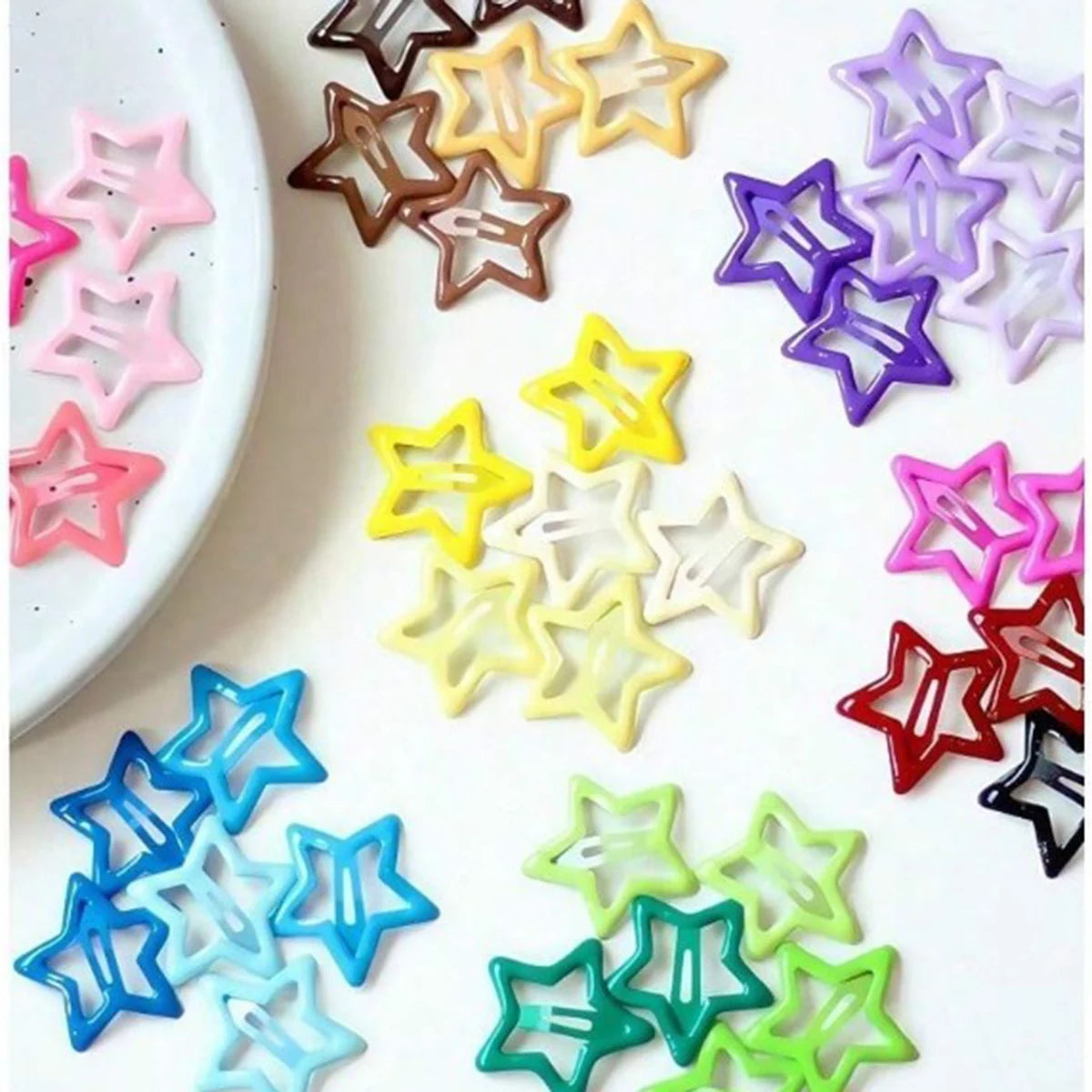 A collection of colorful vintage star hair clips and barrettes in various shades of pink, purple, yellow, blue, and green.