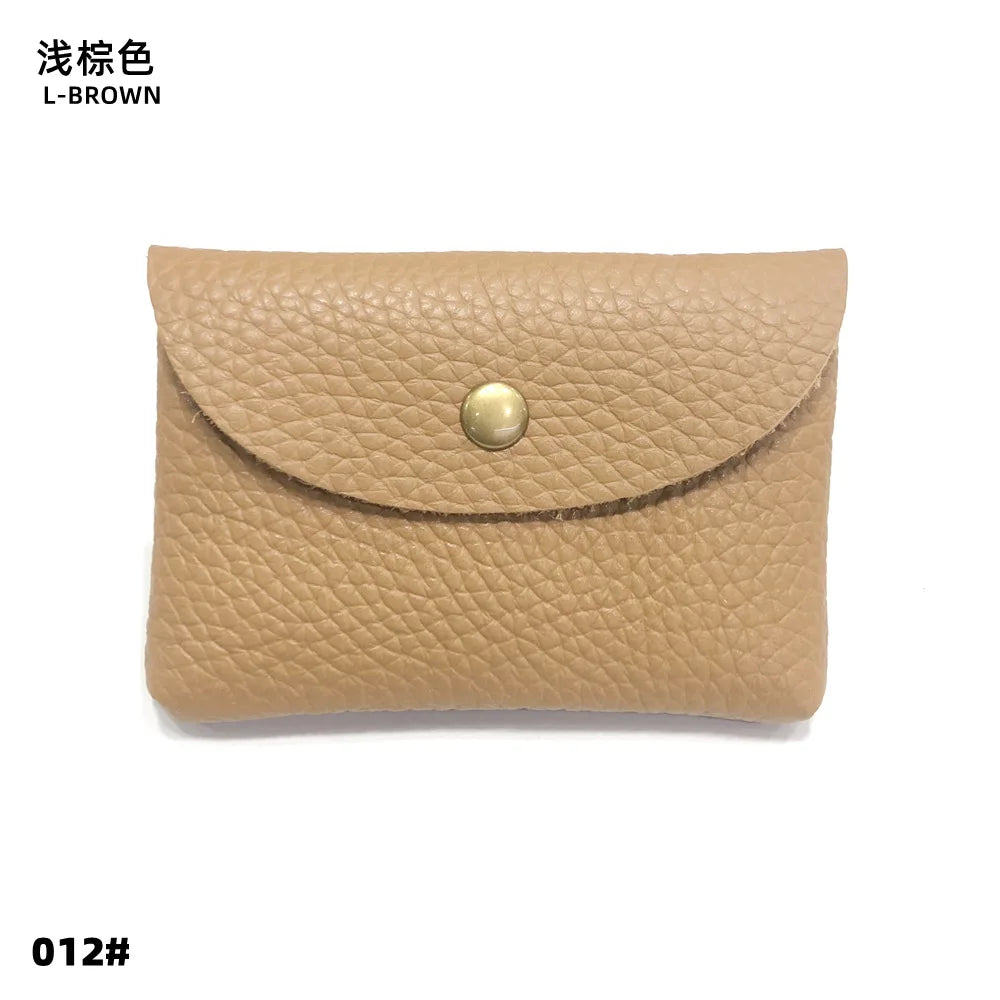 A tan genuine leather card holder or coin purse with a visible stitching detail and a round brass-colored closure.
