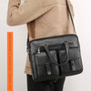 A tan sweater-clad person holds a black PU leather business briefcase bag.