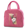 A pink insulated canvas lunch bag featuring a gold letter N and floral embroidery.