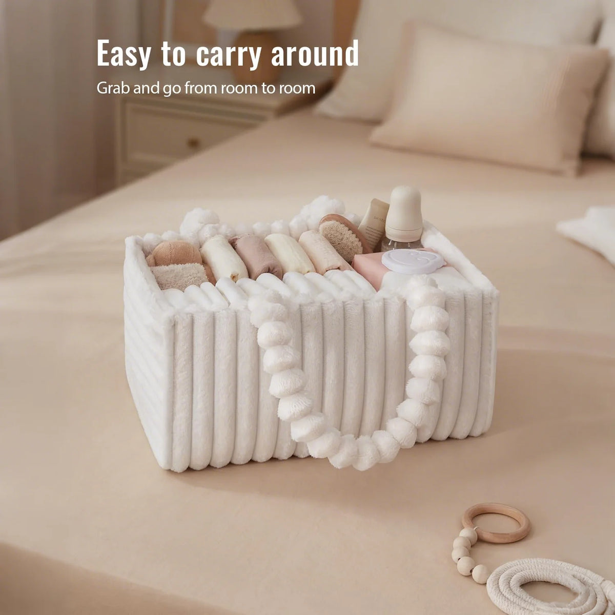 A white flannel diaper caddy organizer filled with various baby items is shown on a beige bed linen.