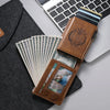 A brown PU leather card holder with a sleeve and a clear plastic window is placed on a laptop next to a stack of US dollar bi