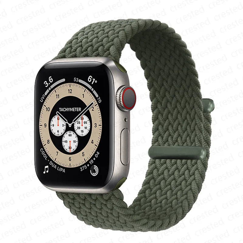 A silver Apple Watch is shown attached to a thick, olive green braided stretch band.