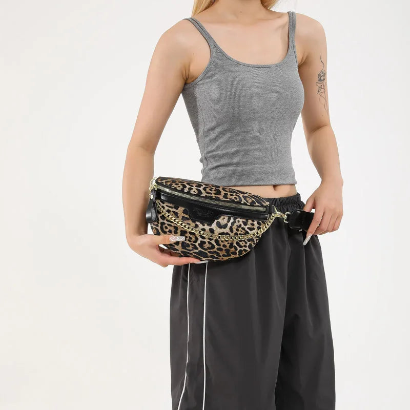 Eine Frau modelliert ein graues Tanktop und schwarze Hose und hält eine Leopardenmuster-Crossbody-Tasche.