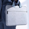 A gray premium laptop sleeve with blue accents is shown being carried by a person.