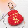 Cartera llavero con forma de corazón, moneda roja, hebilla dorada y signo de dólar amarillo.