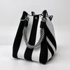 A black and white striped retro knitted bucket handbag with silver hardware.