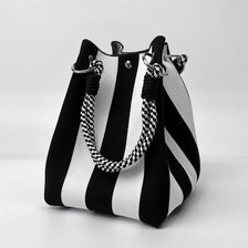 A black and white striped retro knitted bucket handbag with silver hardware.