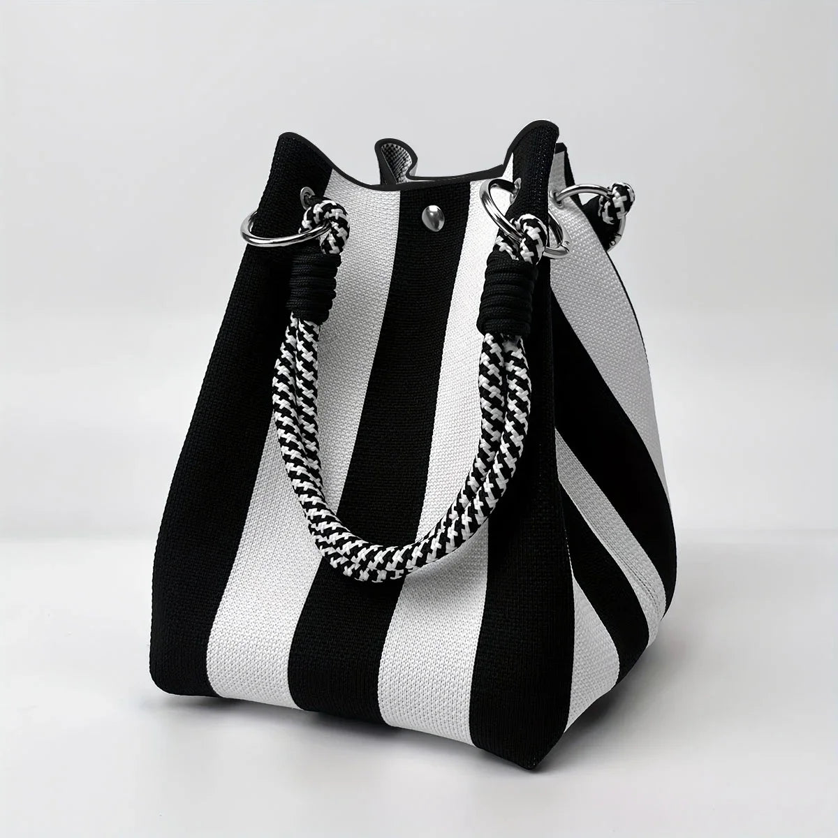 A black and white striped retro knitted bucket handbag with silver hardware.