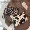A brown blazer features two leopard print faux leather wrist bags with tassels.