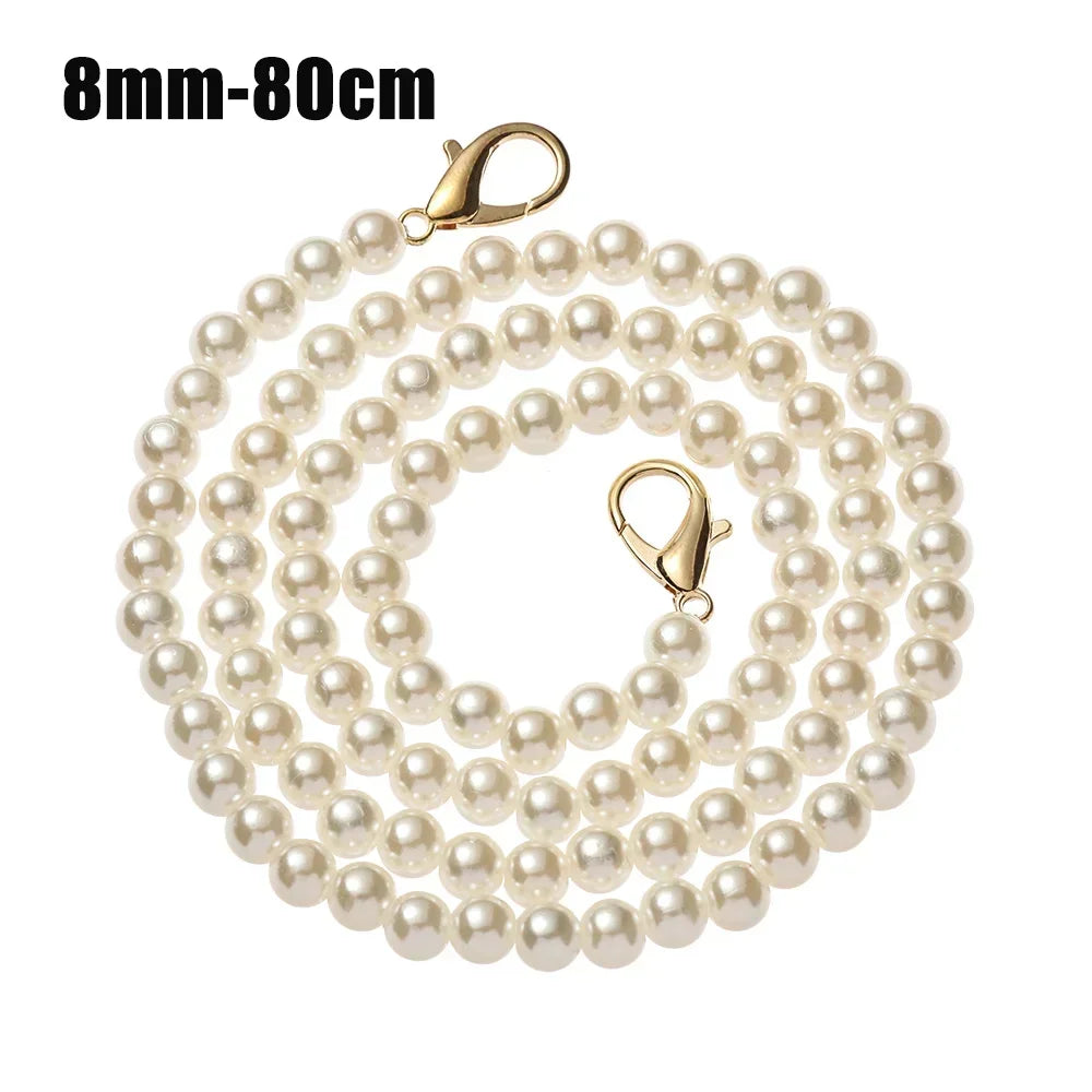 A strand of small, round pearl beads on a thin strap for a handbag or purse.