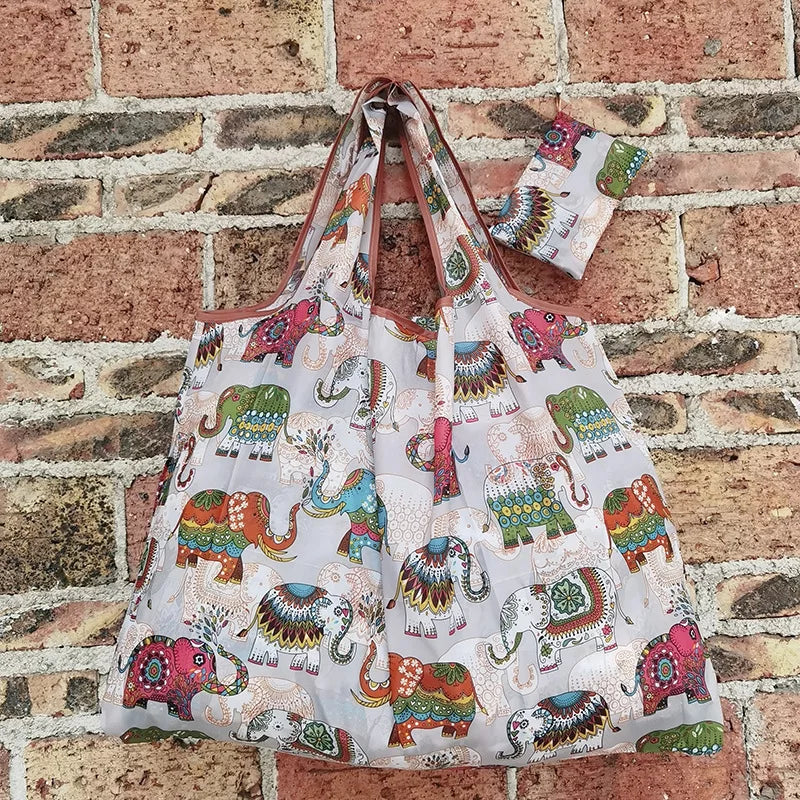 A reusable eco-friendly shopping bag featuring a colorful elephant pattern on a white background.