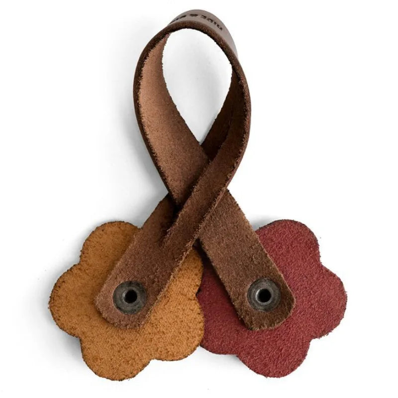 A handmade brown PU leather rose bag charm with a woven design.