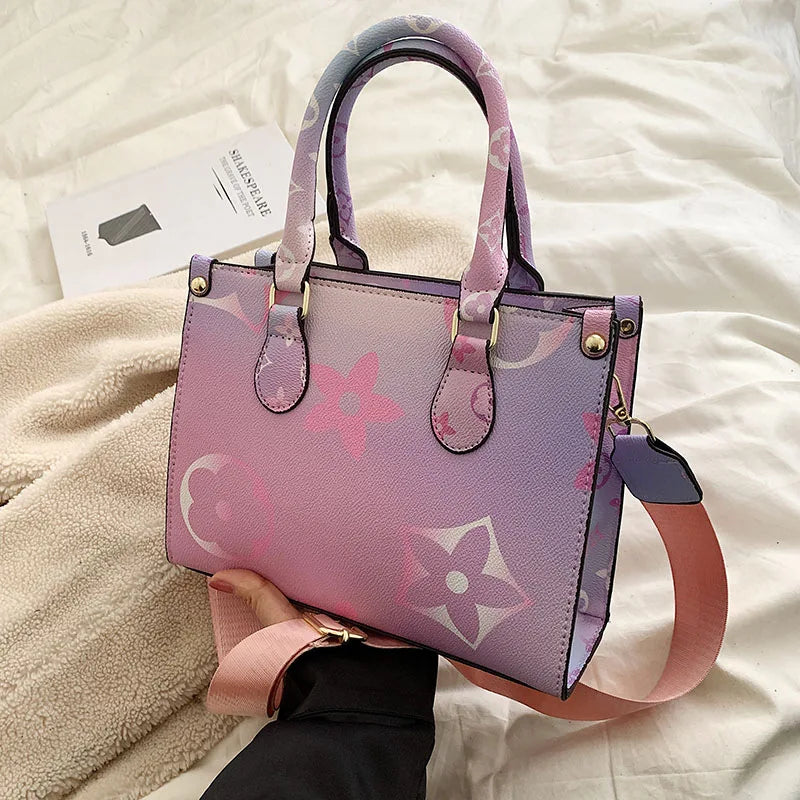 A light purple ladies' shoulder tote bag with pink floral accents resting on a white surface.