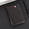 A dark brown slim PU leather credit card wallet with a French flag embossed on the cover, resting on a black surface.