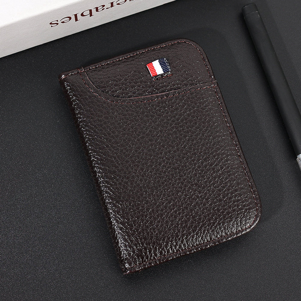 A dark brown slim PU leather credit card wallet with a French flag embossed on the cover, resting on a black surface.