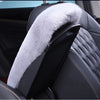 A black car seat featuring a plush, light gray faux fur armrest cushion.