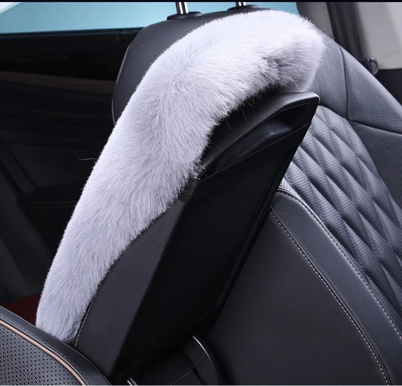 A black car seat featuring a plush, light gray faux fur armrest cushion.