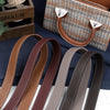 Une collection de bretelles de sac à main en cuir PU marron et beige disposées sur un tissu bleu foncé.