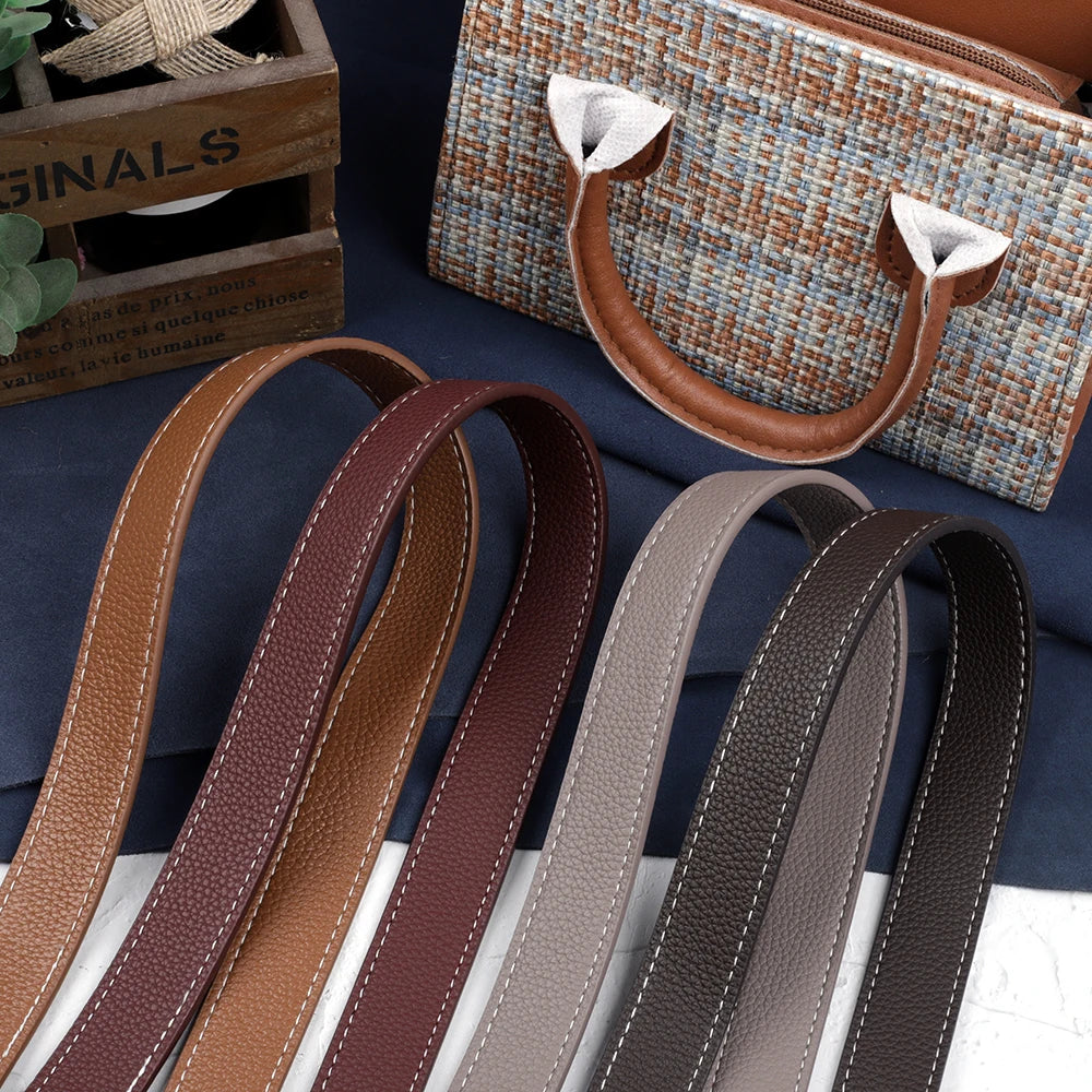 Une collection de bretelles de sac à main en cuir PU marron et beige disposées sur un tissu bleu foncé.