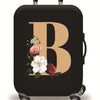 A black suitcase with a large gold letter B and floral accents, shown on rolling wheels.