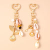 Gold-toned starfish and seashell keychain featuring pink and white pearl accents