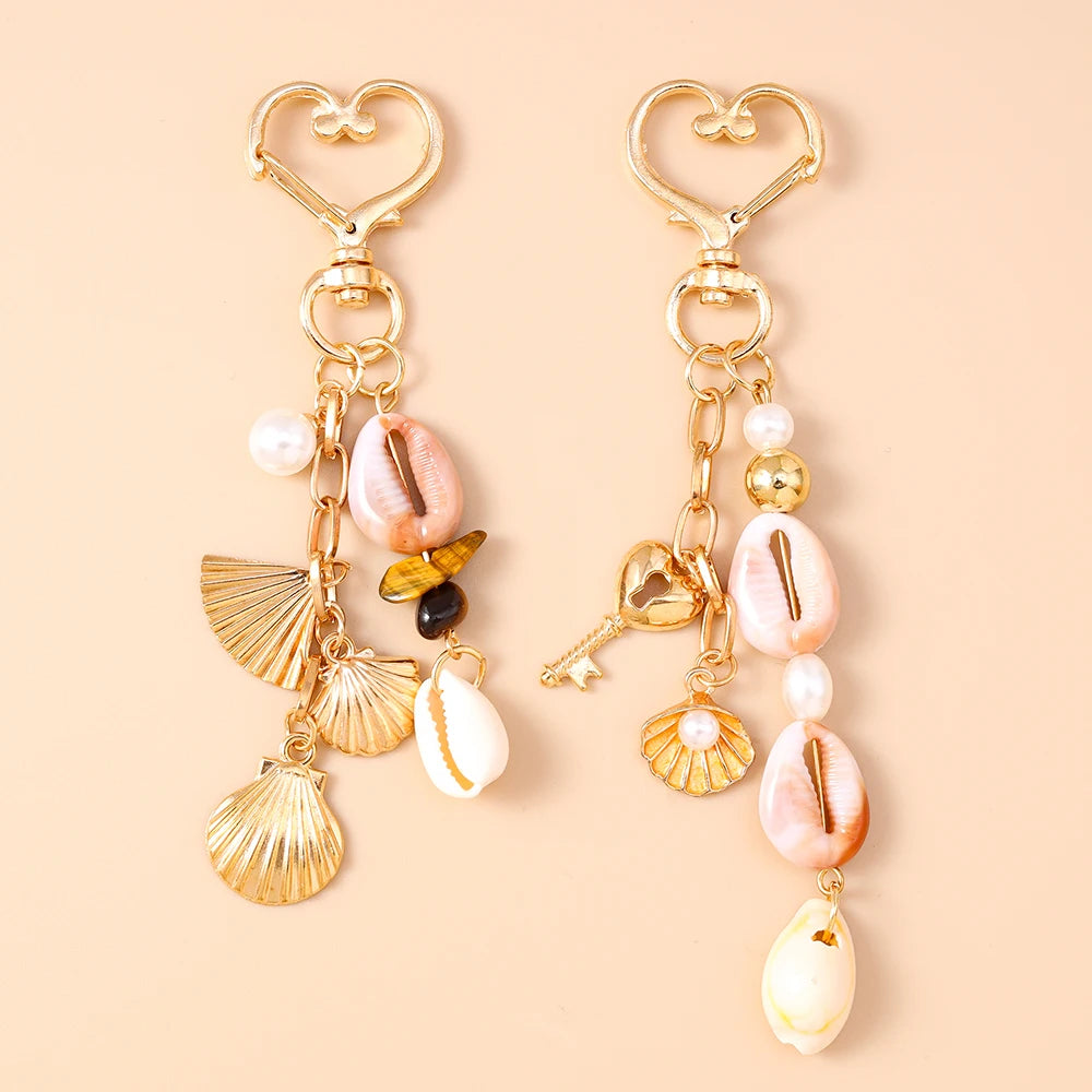 Gold-toned starfish and seashell keychain featuring pink and white pearl accents