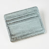 A silver-toned, textured leather mini wallet card holder with horizontal lines.
