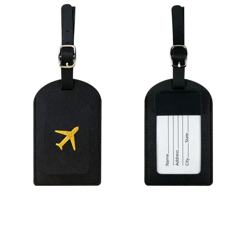 A pair of black PU leather luggage tags with gold airplane emblems and a white address section.