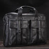 A black genuine leather briefcase with multiple compartments is shown against a dark background.
