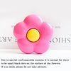 A pink flower shaped phone grip ring stand with small black dots on the surface.