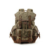 Mochila de senderismo de lona verde oliva con detalles y hebillas de cuero marrón.
