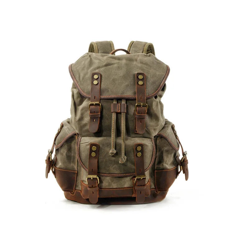 Mochila de senderismo de lona verde oliva con detalles y hebillas de cuero marrón.
