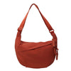 A terracotta orange canvas crossbody bag with a brown leather strap.