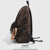 A brown leopard print backpack with black accents shown against a light gray background.