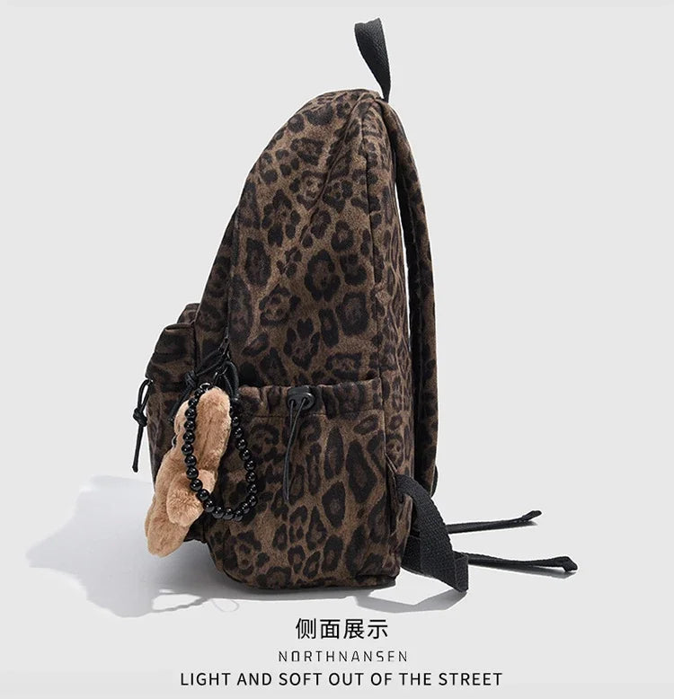 A brown leopard print backpack with black accents shown against a light gray background.