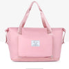 A pink expandable travel organizer bag with handles and a zippered compartment.