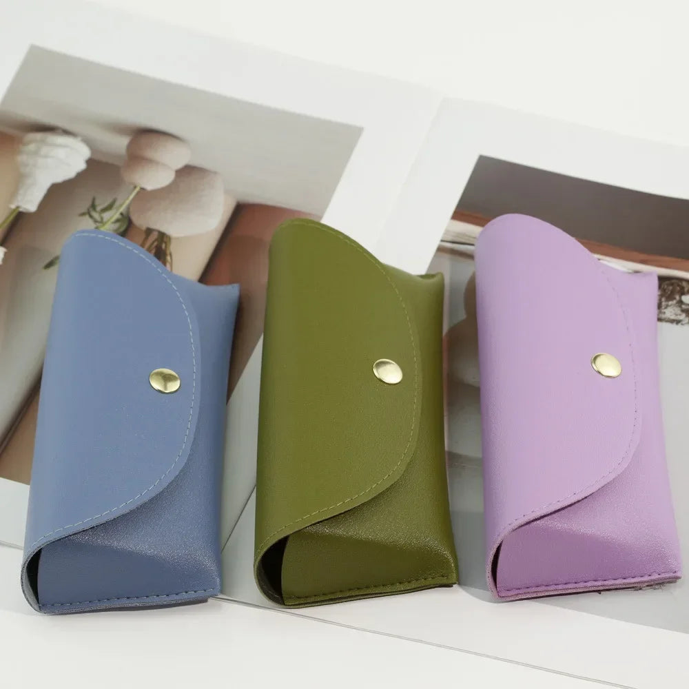 A set of three PU leather hard shell sunglasses cases in shades of blue, olive green, and lavender.