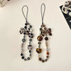 A pair of leopard print bowknot phone lanyards featuring heart and silver beads.