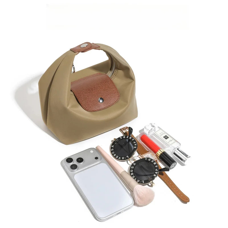 A beige nylon dumpling crossbody shoulder bag with a brown leather accent and various accessories.