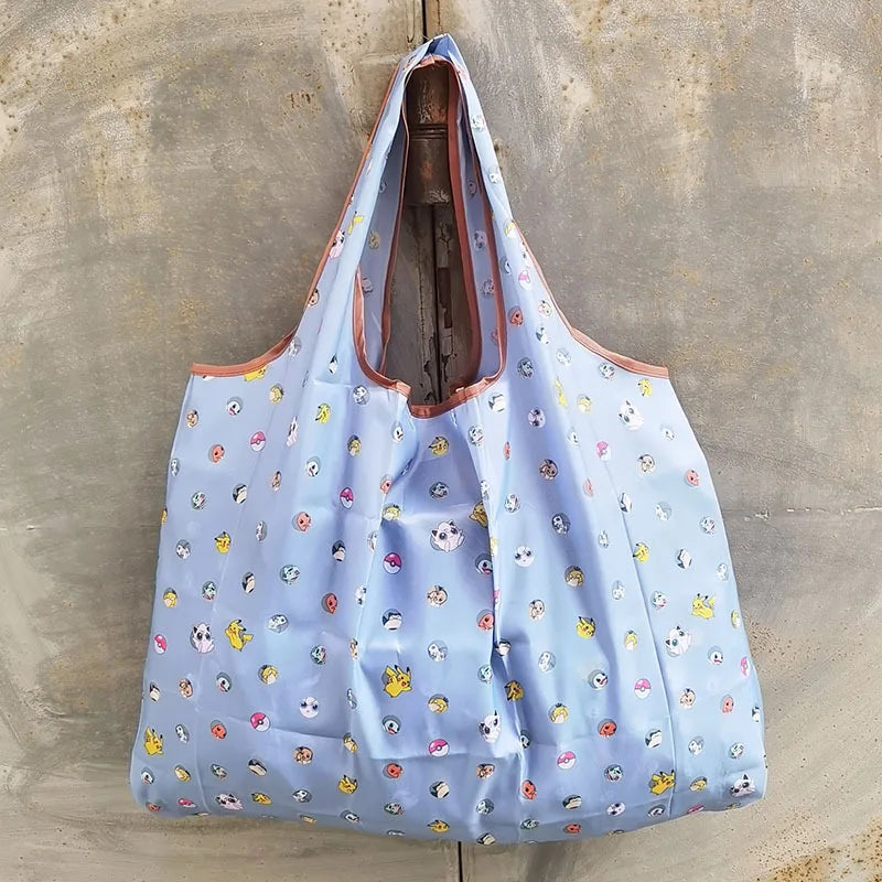 A light blue reusable shopping bag with a floral pattern is displayed against a concrete background.