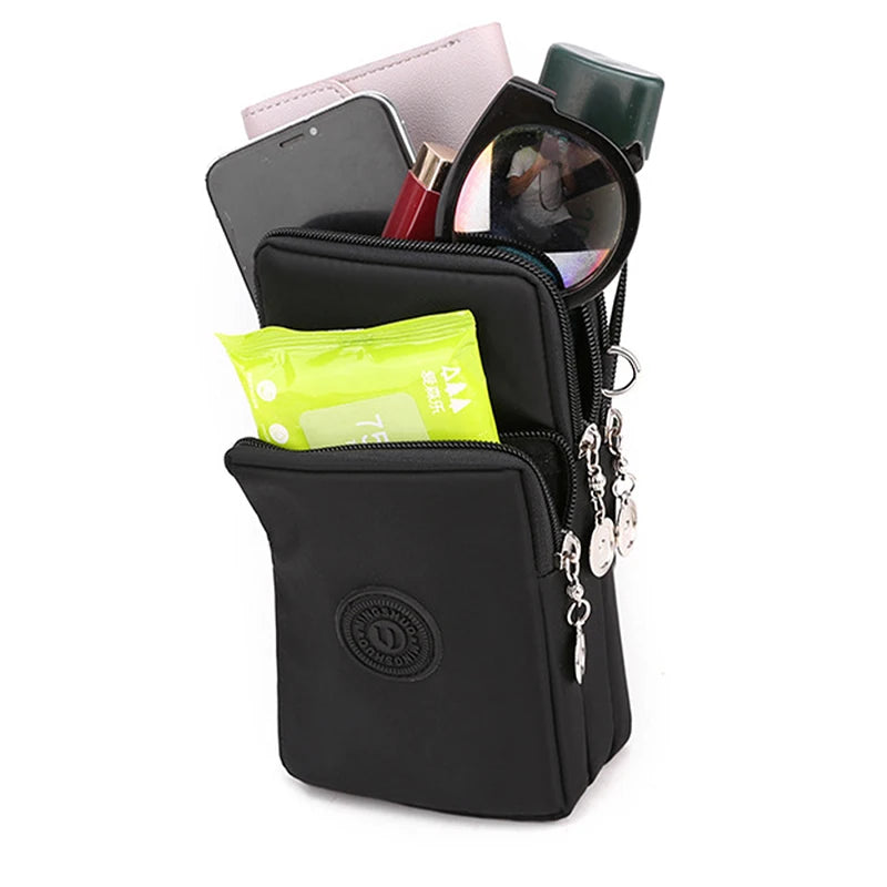 A black compact nylon crossbody phone bag with an adjustable strap and various accessories inside.