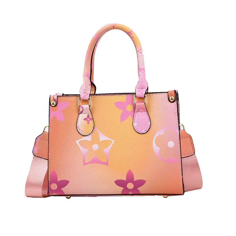 A pink floral patterned ladies shoulder tote bag with pink leather trim and hardware.