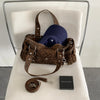 A brown leopard print Rivet Boston shoulder bag with a dark blue hat and a black box.