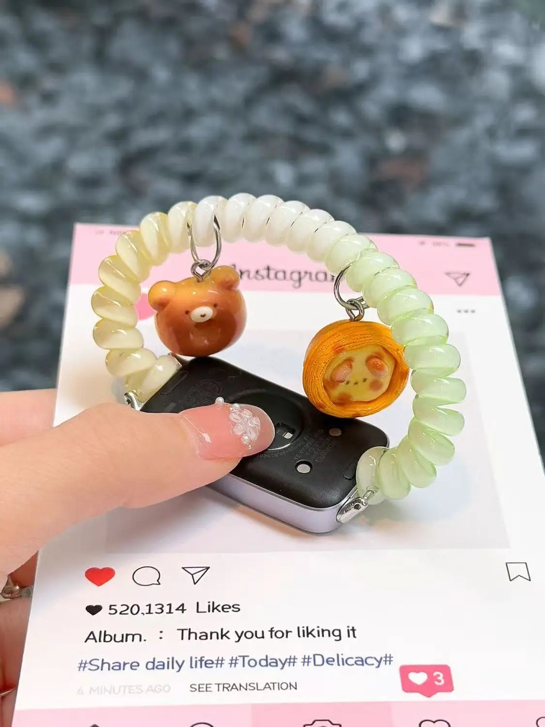 A hand is holding a replacement elastic watch strap for Huawei bands, which is light green and white, next to a smartphone.