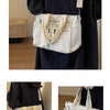A beige striped corduroy tote bag with adjustable straps carried by a person in a black dress.