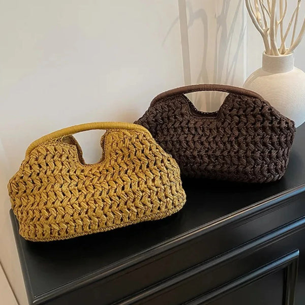 A pair of straw woven tote handbags in yellow and dark brown resting on a black cabinet.
