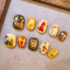 A collection of 12 cute cartoon press-on nails in various colors and designs displayed on a gray surface.